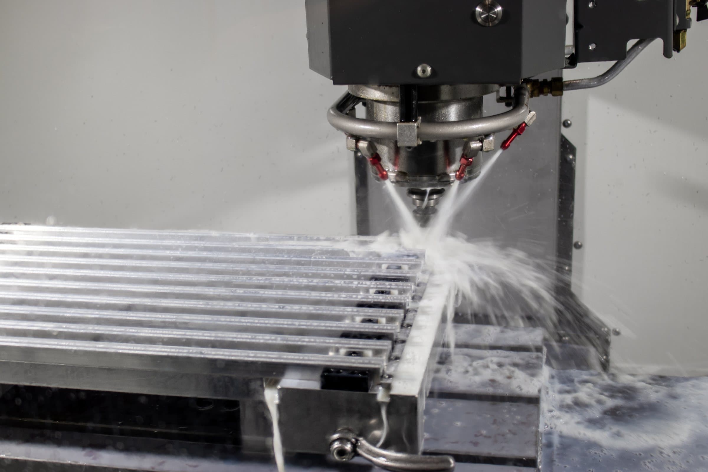 HAAS CNC vertical mill machining aluminum profiles under coolant