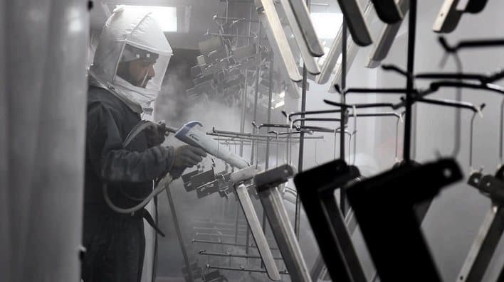 Powder coating technician in a spray booth