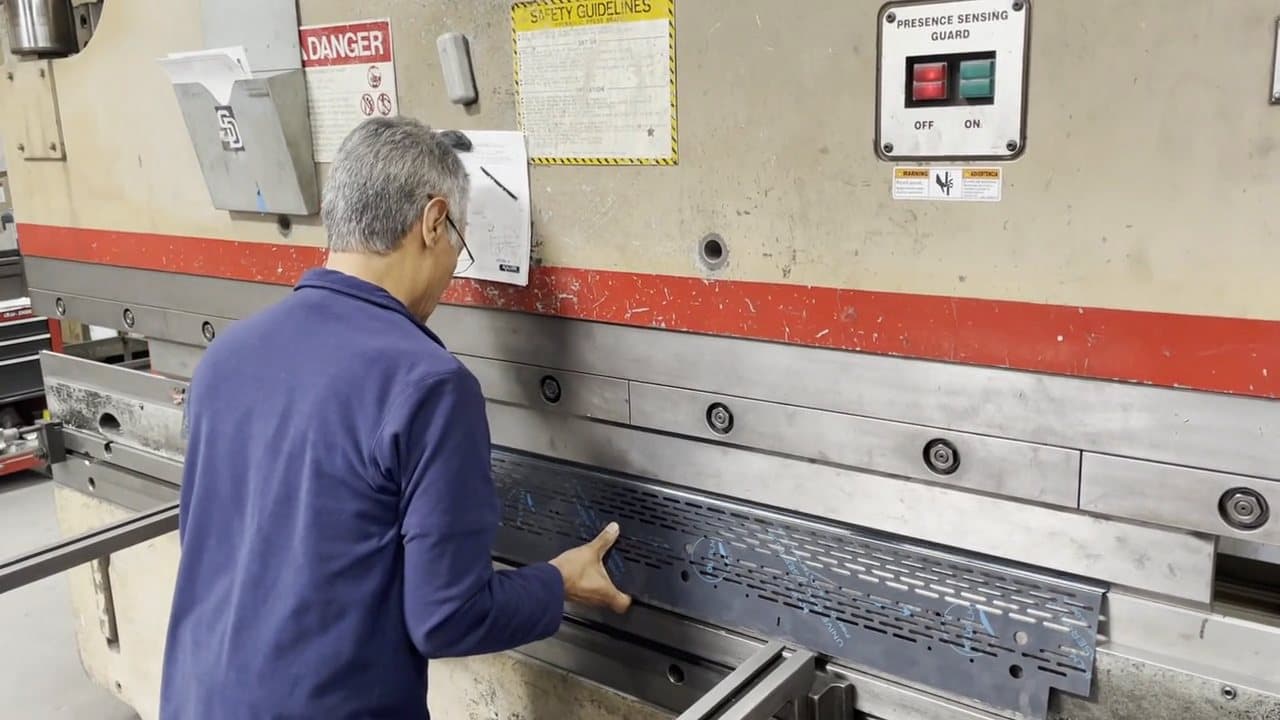 Right Manufacturing operator forming a perforated sheet on a press brake